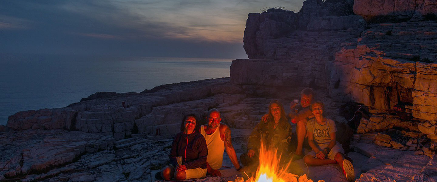 Picture of a family sat around a campfire